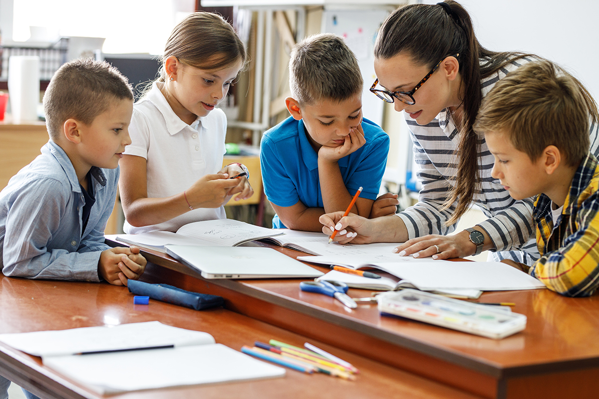 A female teacher spends time with her elementary school students