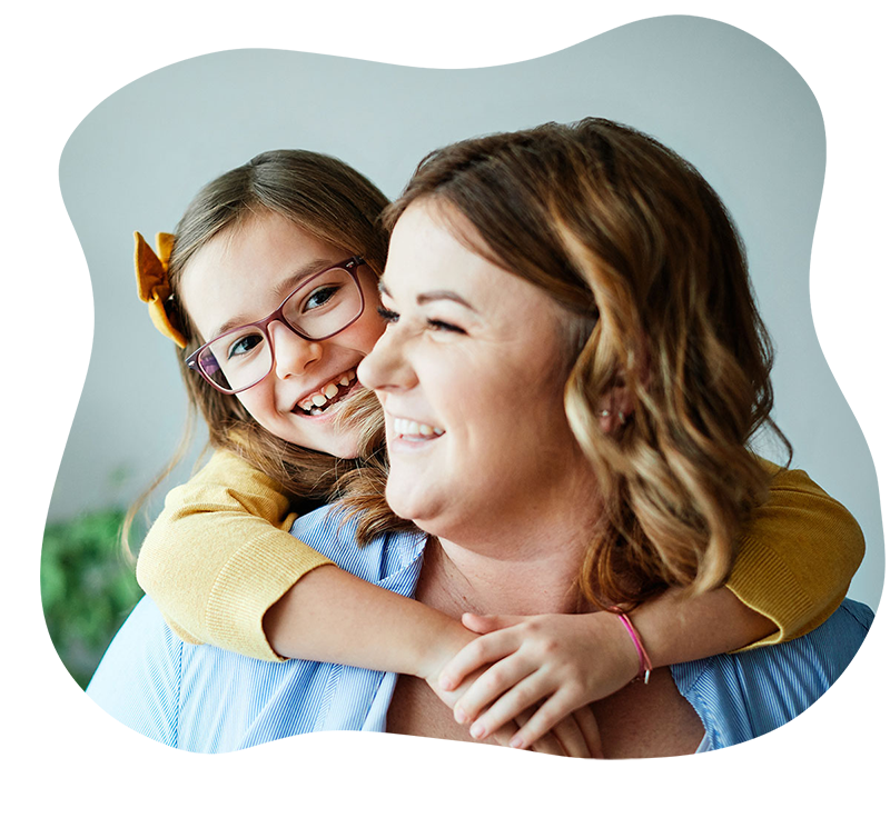 Little girl with arms wrapped around mom from behind